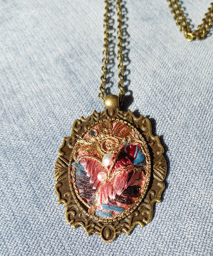 One of a kind, handmade Fabric Pendant. Elegant, brocade ribbon fabric. Arranged in an old fashion historical Cameo bezel. adjustable length