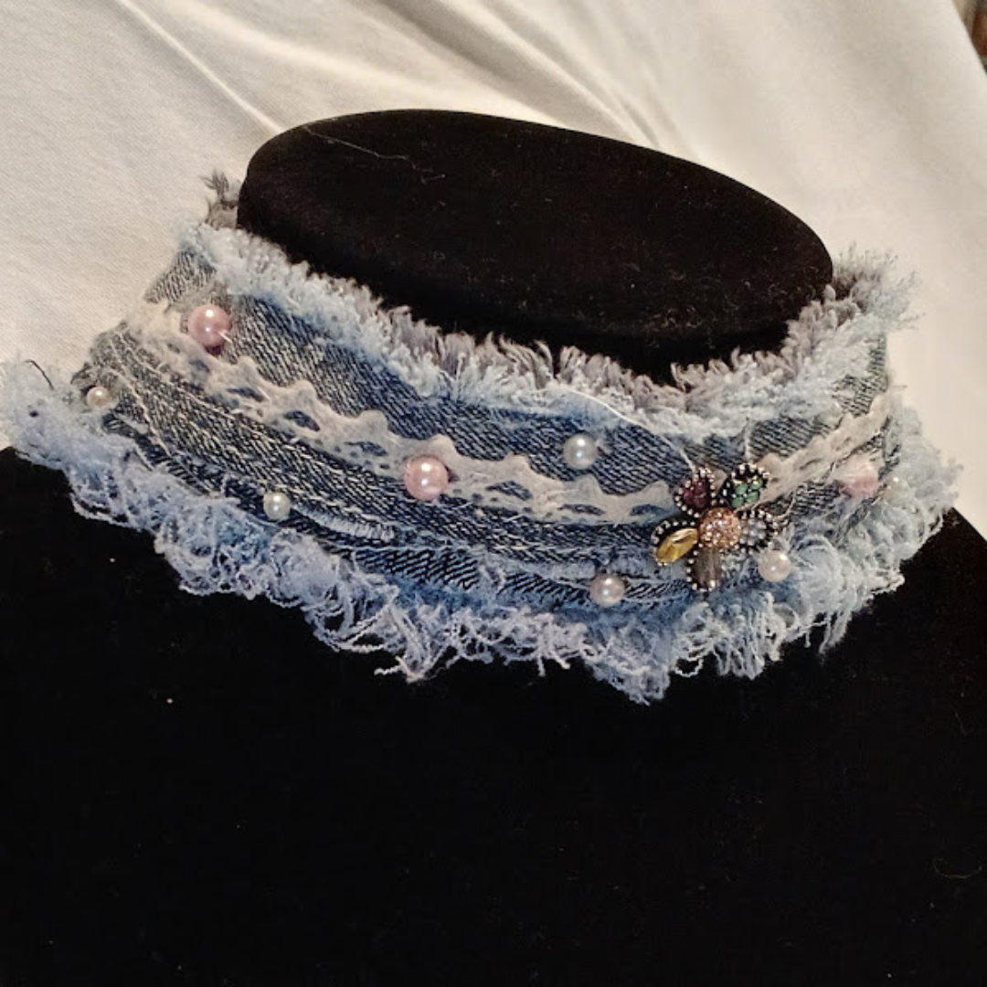 Denim Choker Necklace made of reycled jeans, edges frayed, trimmed in ivory lace, pearls, & a bejeweled button in shape of flower at center