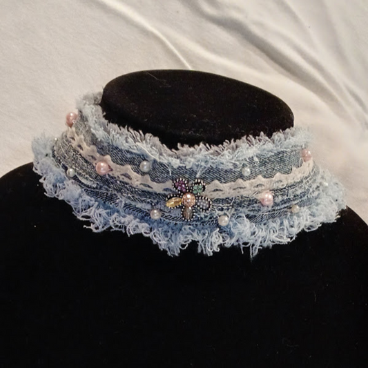 Denim Choker Necklace made of reycled jeans, edges frayed, trimmed in ivory lace, pearls, & a bejeweled button in shape of flower at center