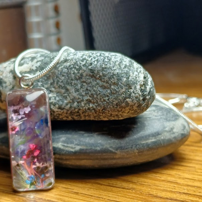 Whimsical Handmade Necklace-Dried flowers in bezel under clear acrylic Cabochon. The curve of the acrylic creates variety of colors, shapes